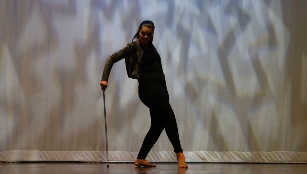 A soloist with a cane in front of a patterned backdrop